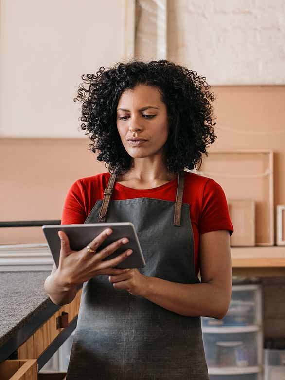 woman looking on tablet for business health insurance quotes and plan options